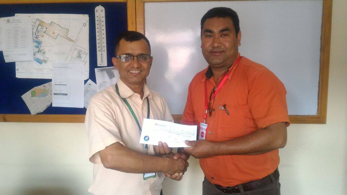Two men shake hands in front of a whiteboard while holding a Deerwalk envelope between them.